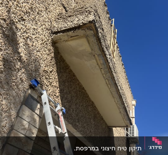סולם ליד קיר חיצוני במהלך שיפוץ